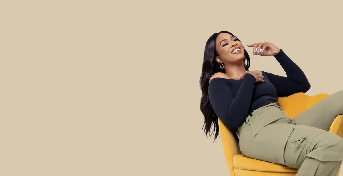 TJL model in an off-shoulder black top and olive cargo pants
