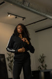 Black track jumpsuit upper-body detail